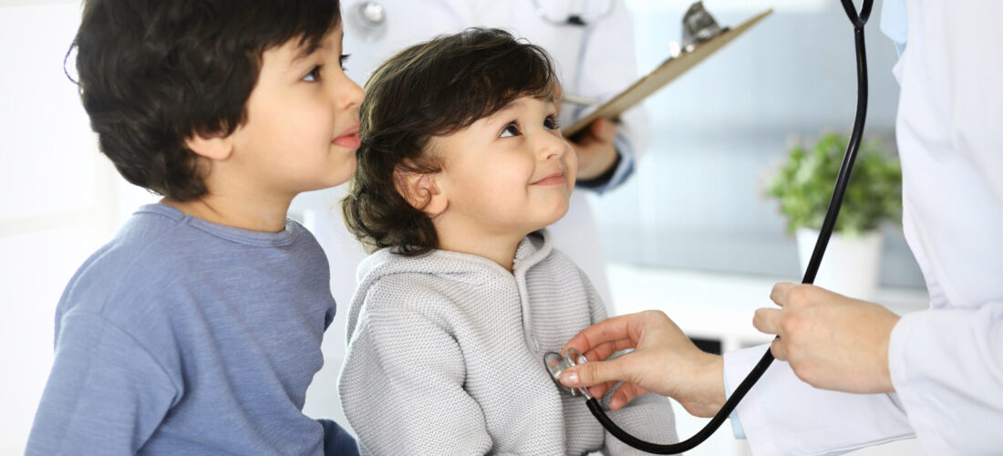 Doctor examining a child patient by stethoscope. Cute baby girl at physician appointment. Medicine concept.